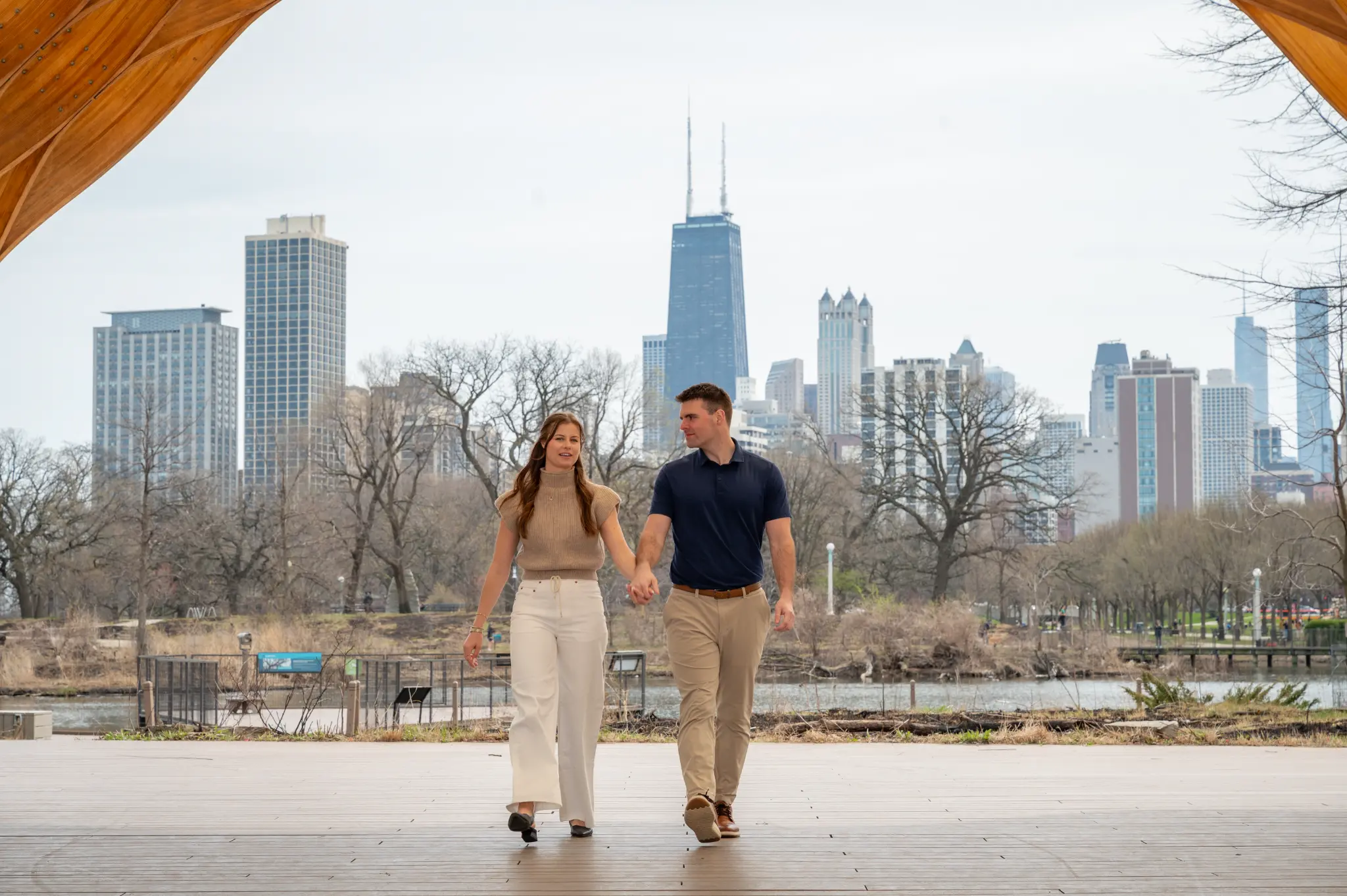 Tom and Anna walking together with the Chicago skyline behind them